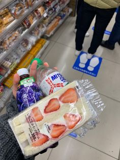 a person holding up a bag of strawberries in a store