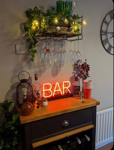 a bar sign sitting on top of a wooden table next to a wine glass rack