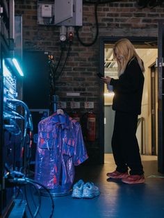 a woman looking at her cell phone while standing in front of a closet