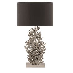 a table lamp with a black shade on it and silver corals in the center