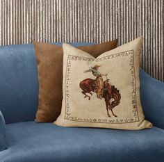 a blue couch with a pillow on top of it and a cowboy riding a horse