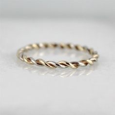 Completely hand made in my studio, this single stacking ring is made from 14K yellow and white gold wire that I twisted myself in my studio to create a rope look. The Twist stacking ring measures approximately 1.5mm in width and is made to order in your finger size. Please indicate your finger size at the time of purchase. One of the special characteristics of handmade jewellery is that there will be subtle differences from piece to piece - your assurance of handmade quality. Each ring made will Stackable Bands With Modern Twist For Promise Ring, Modern Twist Stackable Bands For Promise Ring, Stackable Bands With Modern Twist, Modern Twist Stackable Round Bands, Modern Twist Promise Ring Bands, Adjustable Stackable Rings With Modern Twist For Wedding, Adjustable Stackable Rings With A Modern Twist For Weddings, Modern Twist Adjustable Stackable Rings For Weddings, Modern Twist Adjustable Stackable Wedding Rings