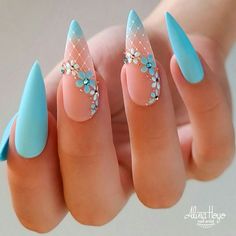 a woman's hand with some blue and pink nail polishes on her nails