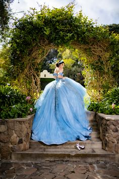 a woman in a blue dress sitting on some steps