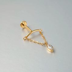 a gold chain with a single diamond on the end and a small white stone in the middle