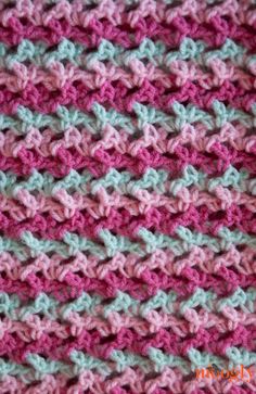 crocheted blanket with pink, blue and green colors