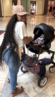 a woman pushing a stroller with a baby in it