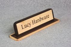 a wooden sign with the word lucy hardware on it's front and bottom