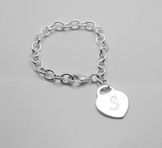 "This personalized bracelet has a semi glossy surface with heart charm which hang off interlocking silver chain The bracelet has a lobster claw clasp. Chain length: 7.5\" Heart charm: 5/8\" Personalize this bracelet with a single initial to make it a unique present for valentine's day, anniversary, birthday, bridesmaid, maid of honor, flower girl or Christmas. Engrave it with a monogram initial (name may be possible but engraved diagonal) Submit your text in the notes when checking out. This ite Silver Engraved Bracelet, Bracelet With Heart, Initial Name, Personalized Bracelet, Personalized Bracelets, Unique Presents, Tiffany Heart, Bridesmaids Gifts, Monogram Initials