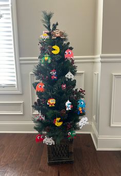 a small christmas tree with mario bros decorations on it's branches in a living room