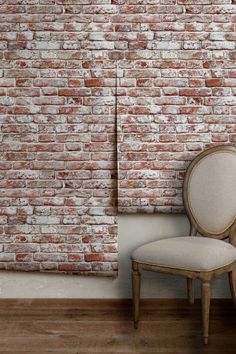 an old chair in front of a brick wall