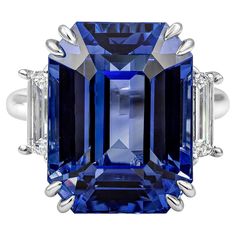 An elegantly made and rare three-stone engagement ring, showcasing an emerald cut heated blue sapphire weighing 26.14 carats. Accented by two step-cut trapezoid diamonds weighing 1.20 carats total. Finely made with a polished platinum mounting. The center stone is certified by GRS as Ceylon/Sri Lankan origin. Size 6.25 US, resizable upon request. Roman Malakov is a custom house, specializing in creating anything you can imagine. If you would like to receive a special quote on a custom piece, ple Diamond Sapphire Engagement Ring, Ceylon Blue Sapphire, Heritage Jewellery, Historical Jewellery, Silver Anniversary, Three Stone Ring, Custom House, Blue Sapphire Diamond, Step Cut