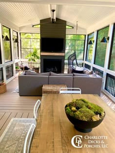 a wooden table topped with a black bowl filled with green moss covered in front of a fire place