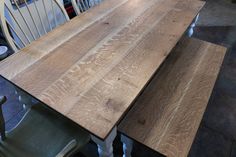 a wooden table with chairs around it in a room full of other tables and chairs