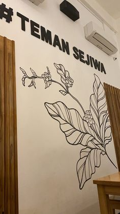 there is a sign that says teman sehwaa on the wall next to a table