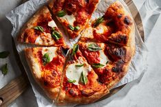 a pizza sitting on top of a wooden cutting board next to a knife and fork