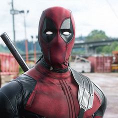 a deadpool is standing in the middle of a parking lot with his head turned to look like he's holding a baseball bat