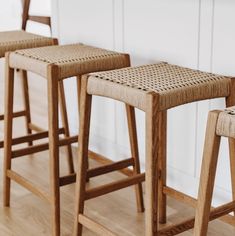 three wooden stools sitting next to each other on top of a hard wood floor