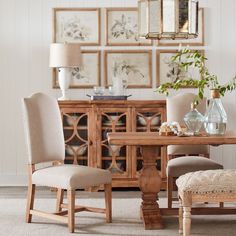 a dining room table and chairs with pictures on the wall behind them in an elegant setting