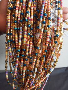 ♕ This Listing is for 20 - 100 Strands of WaistBeads ♕ Wholesale African waist beads. ♕ Ships directly from Ghana, West Africa. ♕ Free shipping via DHL (3 - 5 business days to arrive). ♕ Processing time (5 - 7 business days). ♕ Beads are all TIE-ON (made with cotton thread/polyester). ♕ Length varies from 45 to 50 inches. Multicolor Heishi Beads With Gold Details, Adjustable Multicolor Waist Beads With Gold Beads, Adjustable Multicolor Gold Waist Beads, Adjustable Multicolor Gold Beaded Waist Beads, Multicolor Faceted Beads Waist Beads For Festival, Beads Waist, African Waist Beads, Vinyl Disc, Waist Beads