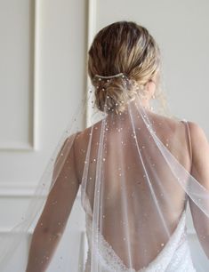 the back of a bride's veil with pearls on it