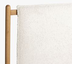 a white towel hanging from a wooden frame