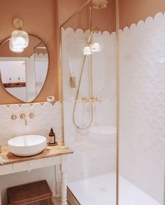 a white sink sitting under a bathroom mirror next to a walk in bathtub and shower