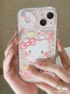 a person holding a clear case with hello kitty on it