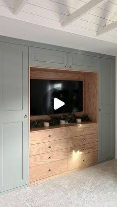 a flat screen tv mounted to the side of a wooden cabinet