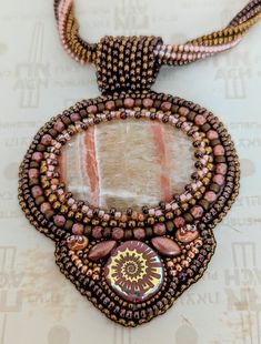 a close up of a necklace on a white surface with beads and other things around it