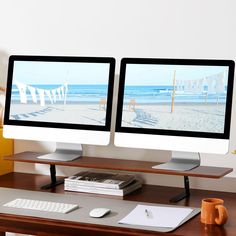 two computer monitors sitting on top of a wooden desk