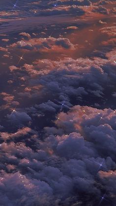 the view from an airplane window looking down on some clouds and stars in the sky