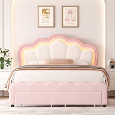 a pink bed with white headboard and foot board in a room that has two pictures on the wall above it