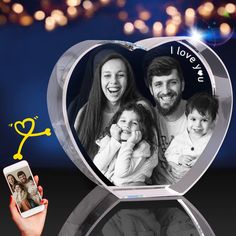 a heart shaped glass photo frame with an image of a family in it