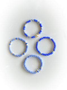 three bracelets with blue beads on white background