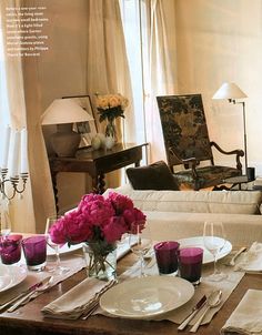 an image of a table setting with flowers in vases and plates on the table