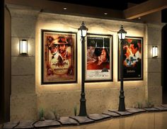 three movie posters are hanging on the wall next to lamps and lights in front of them