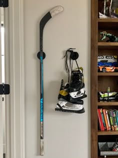 a pair of skis hanging on the wall next to a bookcase with books