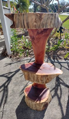 a wooden sculpture sitting on top of a sidewalk