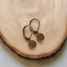 Minimalist dainty brass round drops on lever back earrings. These are perfect for anyone who likes delicate, light weight jewelry.  - Material: Alloy brass tone lever back earrings and tiny charm. - Size: The approximately length is 3/4 of an inch (20mm). The charm size is 5/16 (8mm) in diameter.  - Quantity: One (1) pair. - Jewelry is shipped in packaging ready for gift giving. Thanks for visiting... Minimalist Round Earrings With French Hook, Everyday Hypoallergenic Brass Earrings, Dainty Round Disc Earrings For Everyday, Everyday Round Disc Brass Jewelry, Nickel Free Bronze Minimalist Earrings, Adjustable Gold Jewelry With Lever Back, Minimalist Adjustable Jewelry With French Hook, Dainty Brass Round Hoop Earrings, Dainty Adjustable Earrings With French Hook