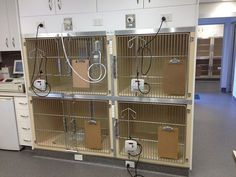 several bird cages with wires attached to them in a room filled with cabinets and drawers