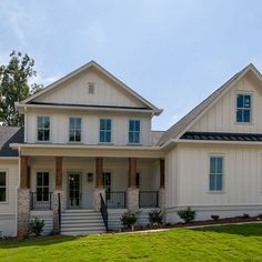 a large white house with two story windows on the front and second story porches