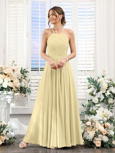 a woman standing in front of flowers wearing a yellow bridesmaid dress