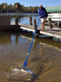 a man is cleaning the water with a blue mop