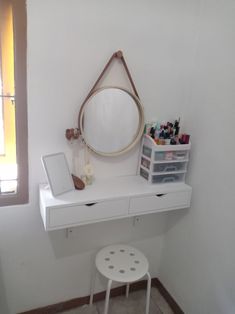 a white desk with a mirror, stool and other items on it in a room