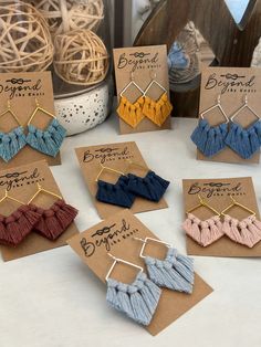 six pairs of tasseled earrings sitting on top of a table next to each other