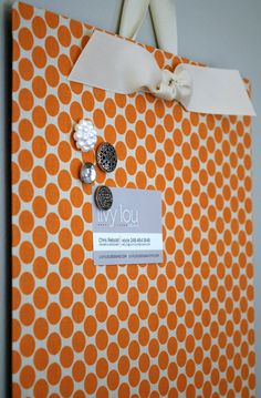 an orange and white polka dot pattern binder with two black buttons on the front