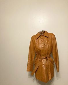 "Early 60s/70s Wilson's leather jacket Tie belt at waist, mod style lines across jacket. Pockets at hips. Buttons up front. Fully lined and in great condition with minimal markings. Labeled size 12, fits like a modern women's small, see measurements which were taken lying flat: 33\" chest 34\" long 24\" sleeves" Retro Long Sleeve Leather Jacket For Work, Retro Leather Jacket For Winter Workwear, Leather Jacket With Belt And Long Sleeves, Retro Winter Leather Jacket For Work, Retro Business Outerwear For Fall, Retro Belted Outerwear For Work, Retro Belted Fall Outerwear, Retro Belted Outerwear For Fall, Brown Belted Leather Jacket With Long Sleeves