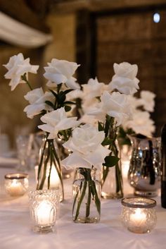 Wedding white roses White Rose Candle Centerpiece Wedding, Simple White Rose Table Decor, Non Candle Centerpieces Wedding, White Roses In Bud Vases Wedding, Roses In Bud Vases Wedding, White Roses Candles Wedding, Wedding White Roses Centerpiece, White Roses In Bud Vases, Simple Wedding Styling