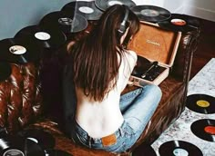 a woman sitting on top of a couch next to record players